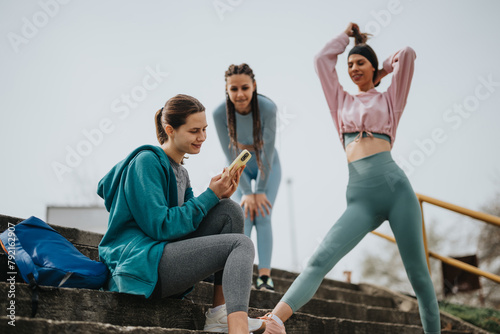 Two fitness enthusiasts rest and stretch during an outdoor workout session on urban steps.