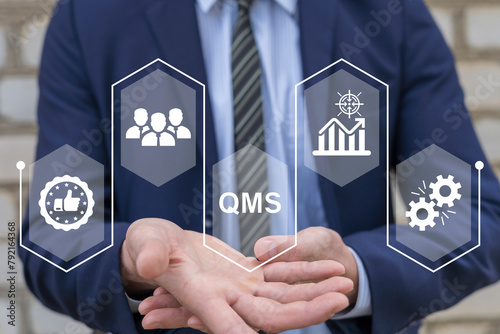 Businessman using virtual touch screen presses text: QMS. QMS - Quality Management System concept. Standards, Documentation, Processes, Audits, Improvement, Compliance, Training, Customer, Continual. photo