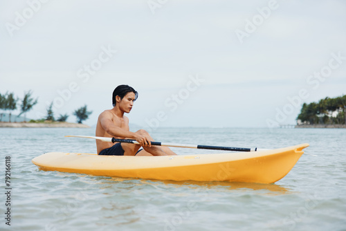Asian Man Kayaking in Tropical Paradise: Adventures on the Beach © SHOTPRIME STUDIO