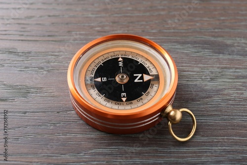 One compass on wooden table, closeup. Tourist equipment