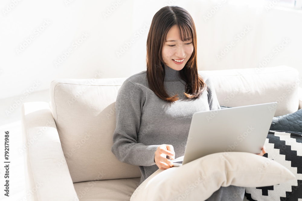 部屋でラップトップコンピューターを見る女性 部屋でラップトップコンピューターを見る女性