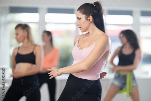 Adult woman dancing high heels at class in group in dance studio