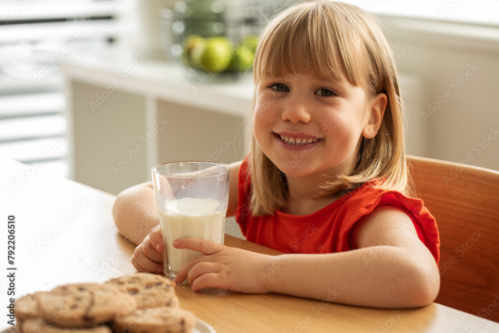 Cheerful girl enjoying fresh milk and homemade cookies, perfect for a wholesome snack time. Cheerful girl enjoying fresh milk and homemade cookies, perfect for a wholesome snack time.