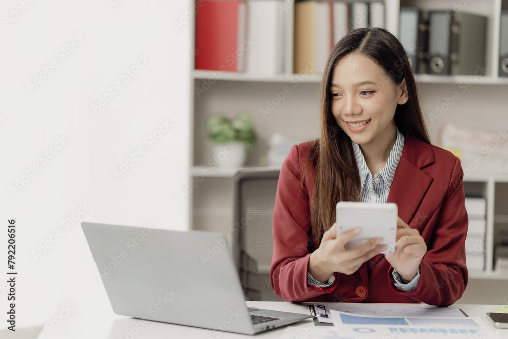 Asian businesswoman uses calculator and laptop to do finance, mathematics, taxes, accounting reports, statistics and business analytical research ideas.