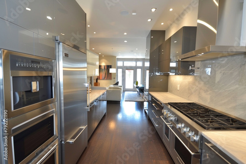 A modern kitchen with sleek cabinetry and integrated appliances, illuminated by recessed lighting overhead.