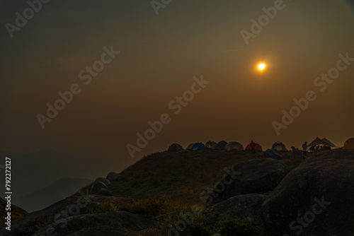 A group of tents are set up on a hillside
