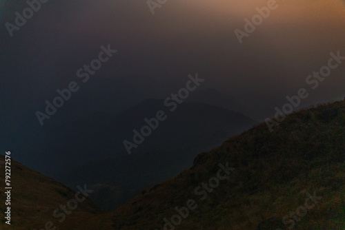 A blurry image of a mountain range with a dark sky