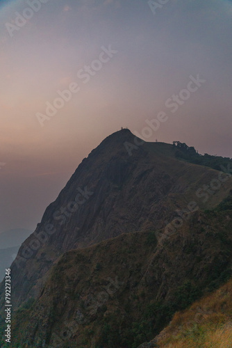 A mountain with a cloudy sky in the background