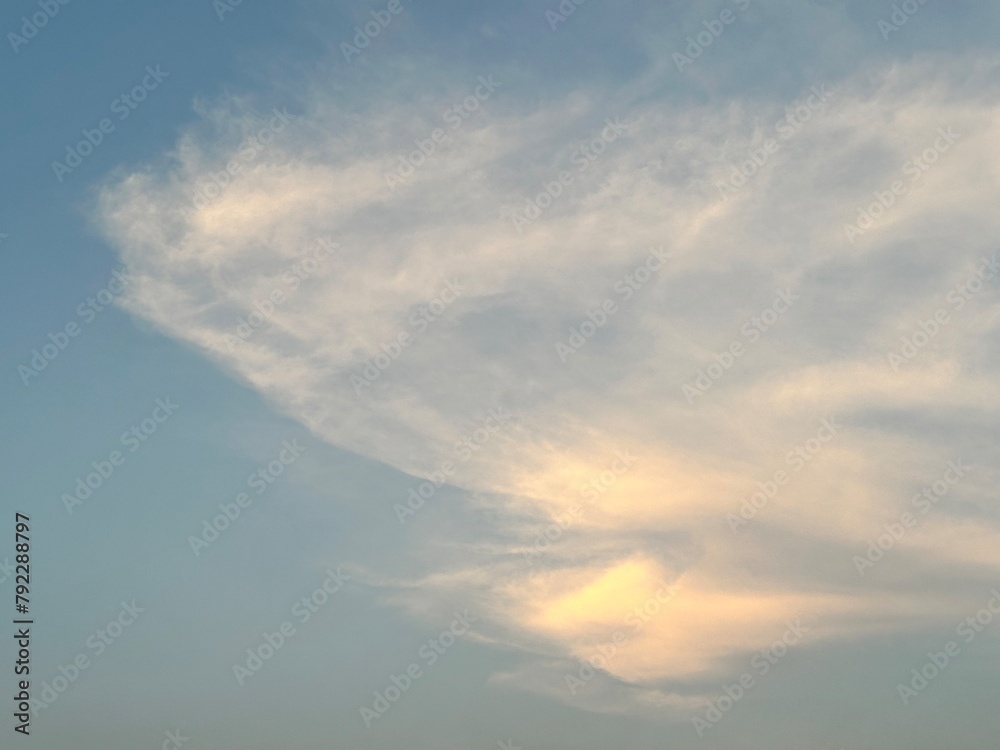 Beautiful clouds in the sky in warm blue and golden sunlight for background