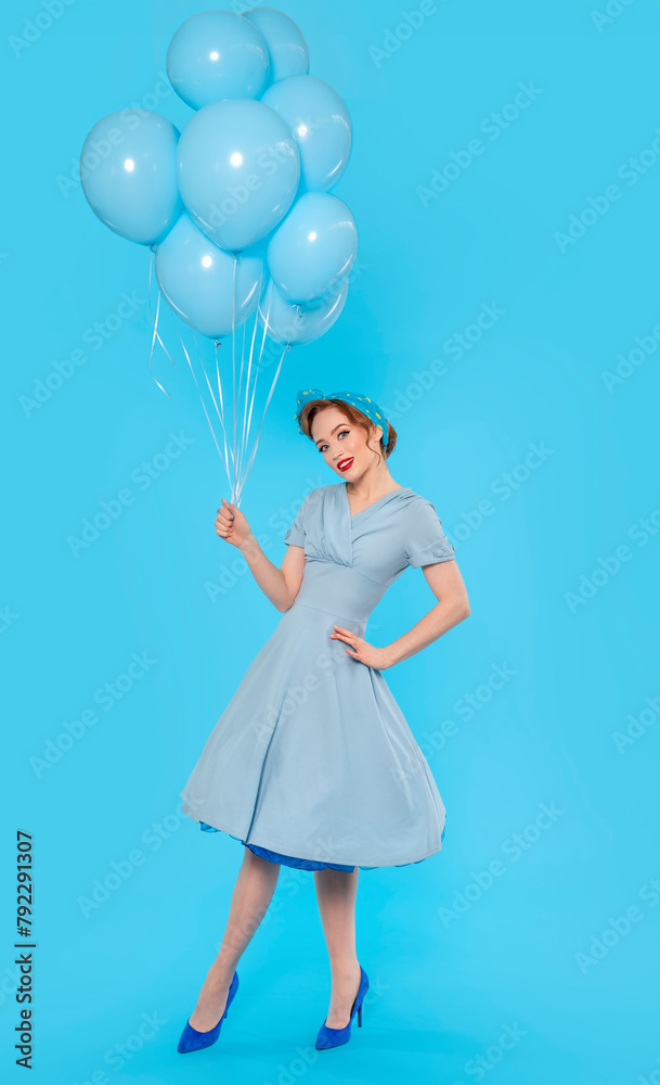 Pin-up girl in dress and heels with balloon on blue background