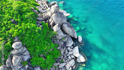 Majestic rocky shores meet lush forests against the backdrop of crystal blue waters, a captivating blend of nature's finest hues. Aerial view. Koh Nangyuan, Southern Thailand. Sea background.   © Punyawee