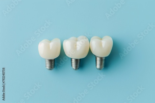 Plastic dental crowns mimic dental bridge for three teeth with metal implant on blue background