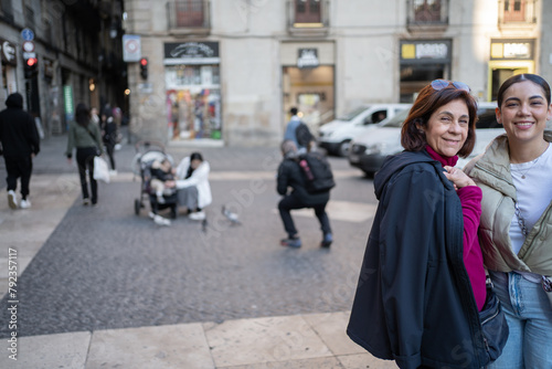 Madre e hija están sonriendo en una calle del Centro Histórico de Barcelona España.