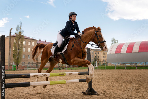 Rider jumping horse over obstacle, equestrian sport. © Vagengeim