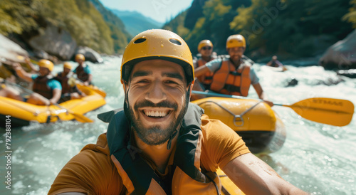 Handsome man and friends wearing life jackets and helmets, smiling while white water rafting in a river on a sunny day