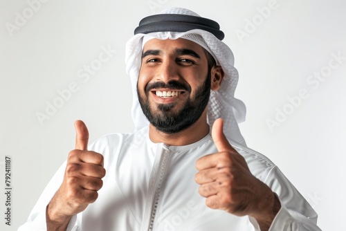 Successful Emirati man giving thumbs up in UAE making OK sign on white background photo