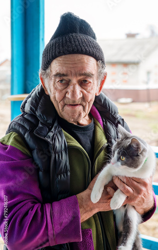 Old Russian man holding his cat and smiling