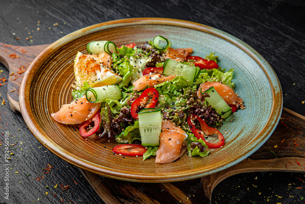 Fresh diet salad with salmon, avocado and greens. Menu for a pub on a dark background. Colorful juicy food photography. Fresh diet salad with salmon, avocado and greens. Menu for a pub on a dark background. Colorful juicy food photography.