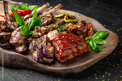 Meat set. A dish of different types of meat: beef steak, pork cuts and ribs, chicken kebab and grilled quail, lamb ribs. Menu for a pub on a dark background. photo