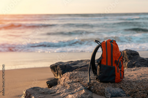 Orange backpack on the seaside against the sea in fantastic weather. Travel insurance concept. Travel light