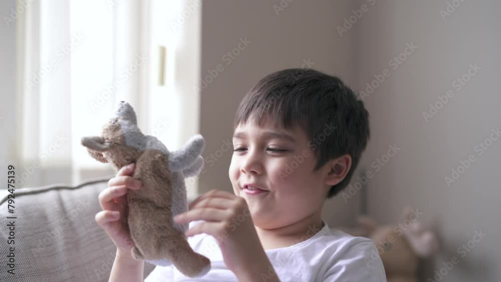 Kid boy smiling face playing with plush toy,Adorable little boy playing with soft dog toy,Hight key portrait child relaxing at home in summer,Positive children with a happy face sitting in living room Kid boy smiling face playing with plush toy,Adorable little boy playing with soft dog toy,Hight key portrait child relaxing at home in summer,Positive children with a happy face sitting in living room