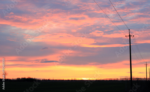 Power line poles against the dawn sky