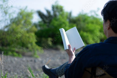 外で読書する男性
