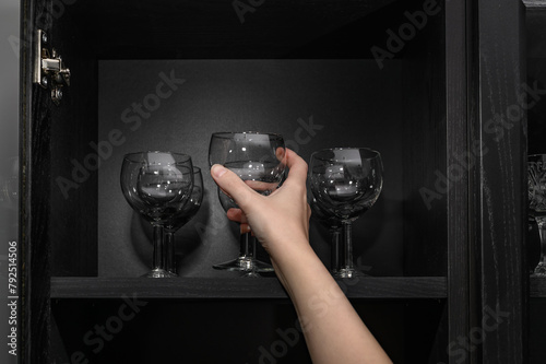Wyjmować szklany kieliszek na wino z kredensu