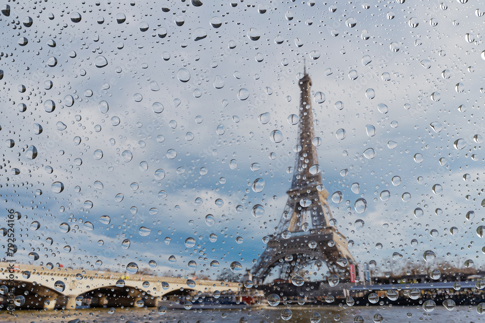 Naklejka premium View on Paris city through water drops on glass after rain. Weather and forecast concept.