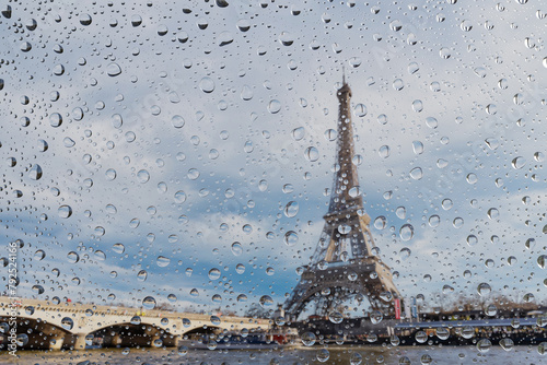 View on Paris city through water drops on glass after rain. Weather and forecast concept. © vchalup