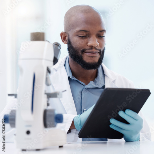 Black man, scientist and tablet in laboratory for research, innovation or healthcare with gloves for hygiene. Male person, studying or planning in lab for medical diagnosis, test or experiment