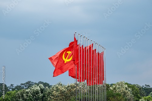 Fotografi Large communist flags floating in the wind with a blue sky background