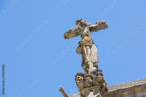 A close-up of a weathered Jesus Christ statue on a cross with intricate details and sky in the background  capturing the essence of faith and history