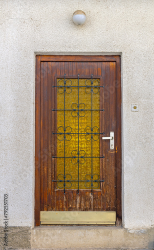Wooden Door With Yellow Window and Bars House Entrance