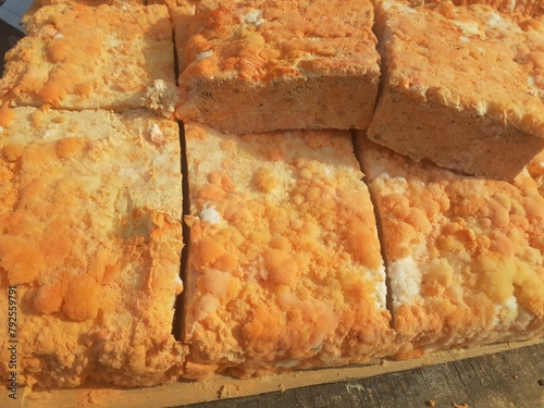 Raw oncom on a wooden shelf at a traditional roadside market trader.Oncom is mushroom-infused tempeh made from peanut cake and tofu dregs.Oncom is a fermented food with several types of mold. photo