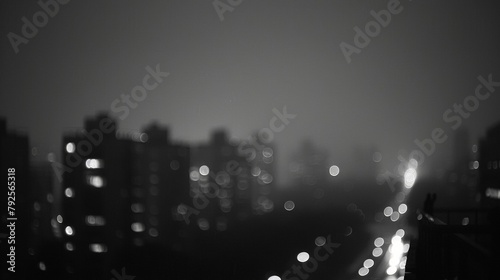 In the distance the city takes on a ghostly appearance the blurred shapes fading into the night as darkness sets in emphasizing the emptiness of midnight solitude. .