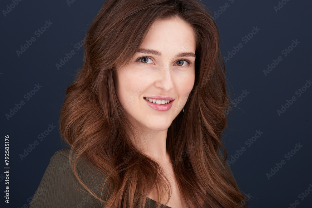 A close-up portrait of a beautiful young woman with pearly white teeth and green eyes looking directly into the camera