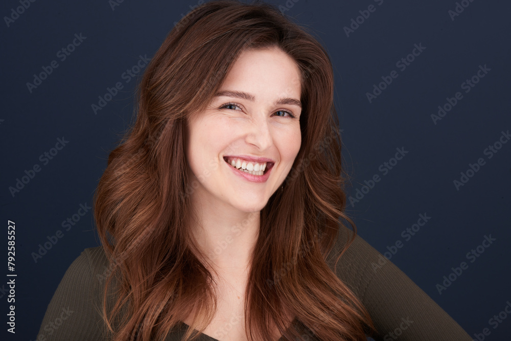 A close-up portrait of a beautiful young woman with pearly white teeth and green eyes looking directly into the camera with a lovely smile