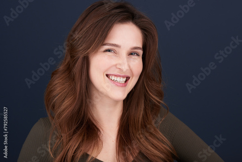 A close-up portrait of a beautiful young woman with pearly white teeth and green eyes looking directly into the camera with a lovely smile