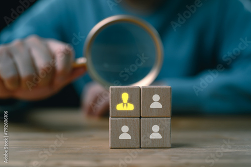 HRM or Human Resource Management, Magnifier glass focus to manager icon which is among staff icons for human development recruitment leadership and customer target group concept. © Looker_Studio