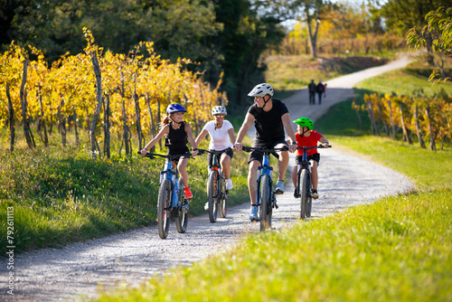 Family of four riding e-bikes in beautiful nature in autumn © JRP Studio