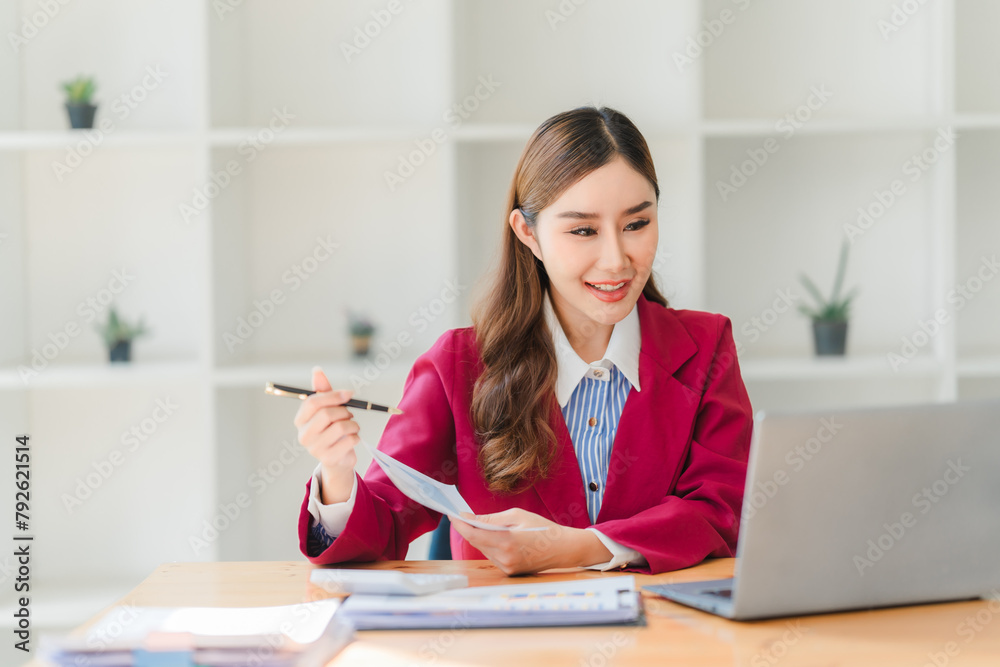 Young adorable businesswoman working with her laptop while standing in the office room