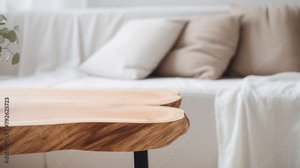 A wooden table top made of sawn wood in the interior of the room on the background of a sofa - obrazy, fototapety, plakaty 