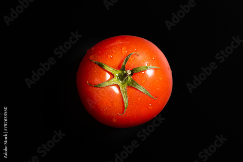 Fresh tomato isolated against black background. Organic tomato, top view