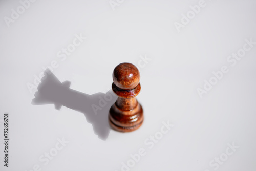 chess pawn sees itself as a queen in the reflection of a shadow