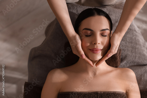 Spa therapy. Beautiful young woman lying on table during massage in salon, top view. Space for text