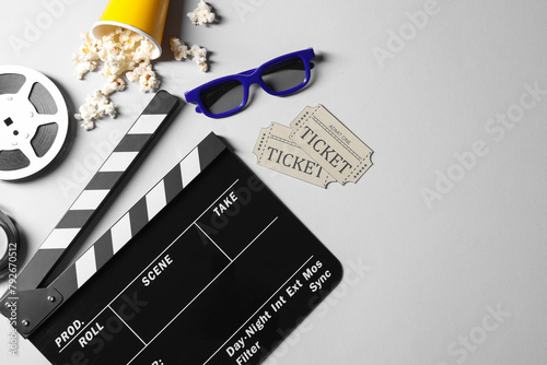 Flat lay composition with clapperboard, film reel and 3D glasses on grey background, space for text