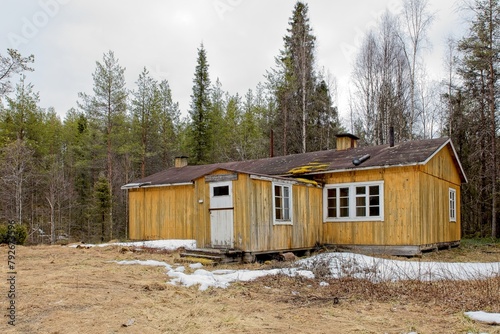 Old log lumberjack bunkhouse  in cloudy spring weather at Riutukka Log Floating Museum, Salla, Lapland, Finland. photo