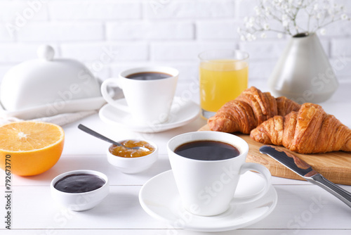 Cup of coffee  jam and croissants on white wooden table. Tasty breakfast
