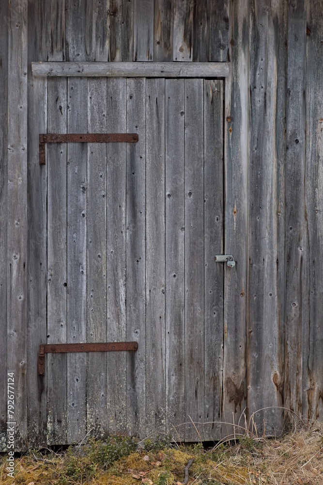Locked weathered door on a wood building.